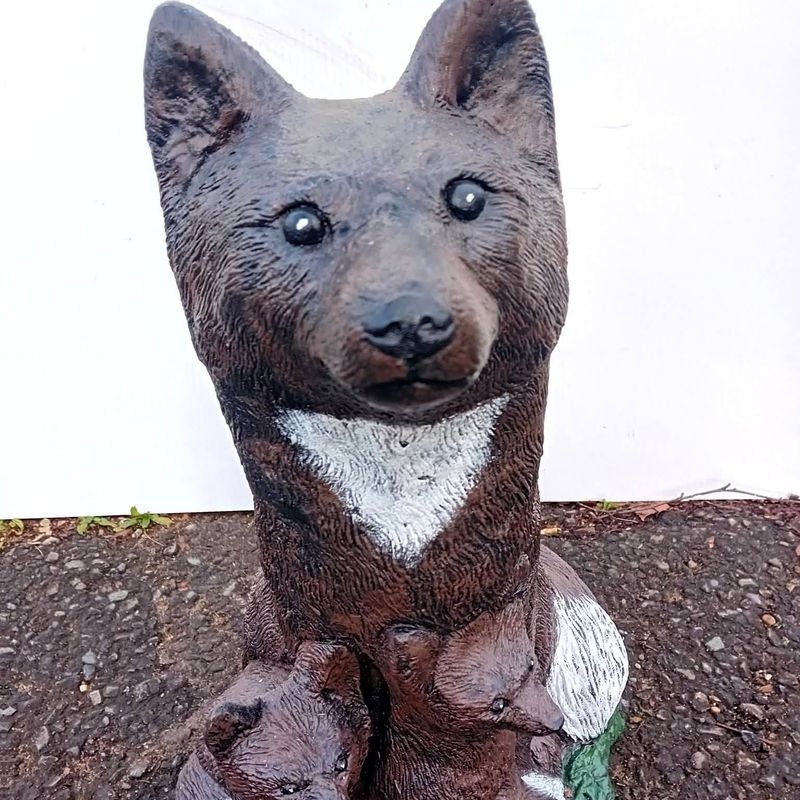 Upright fox hand-painted in russet brown with a white chest, with two cubs at its feet