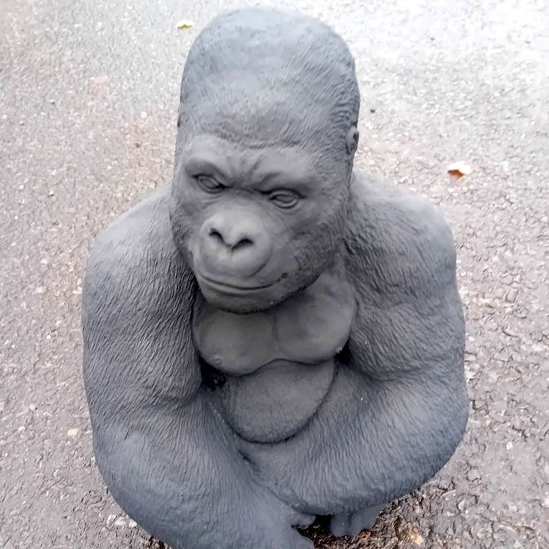 Crouching gorilla statue in natural grey concrete, close up